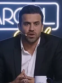 Homem de terno falando em estúdio de entrevista
